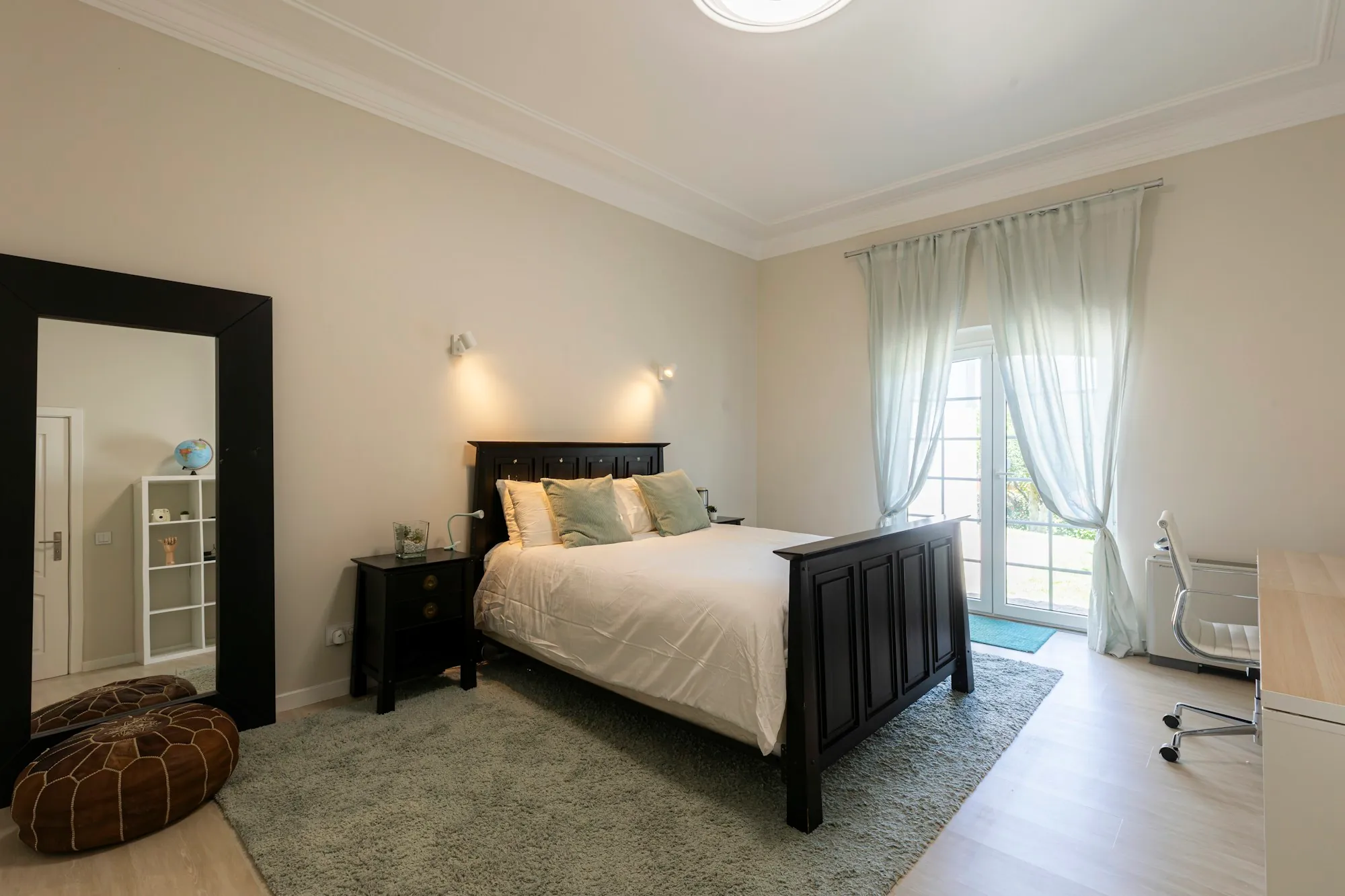 Bright bedroom with a dark wood bed and white linens